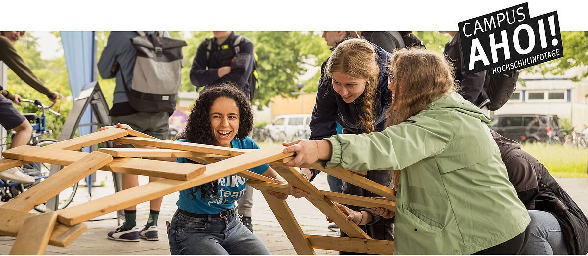 Eine Studentin baut mit Schülerinnen eine Leonardobrücke am Hochschulinfotag