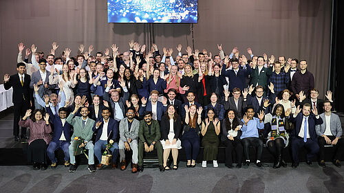 Nach dem akademischen Festakt versammeln sich die teilnehmenden Absolventinnen und Absolventen der Fakultät für Ingenieurwissenschaften auf der Bühne zum Gruppenbild