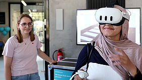 Ein Mädchen mit Kopftuch trägt eine VR-Brille.